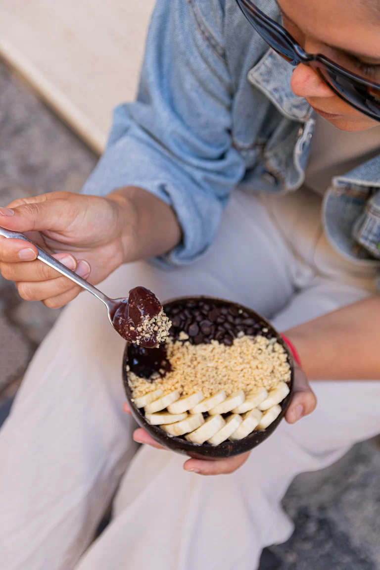 foto de una persona comiendo un Açaí bowl, disfrutando de los beneficios del acai para una alimentación vegana