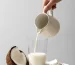 leche de coco servida desde una jarra a un vaso, leches vegetales en españa